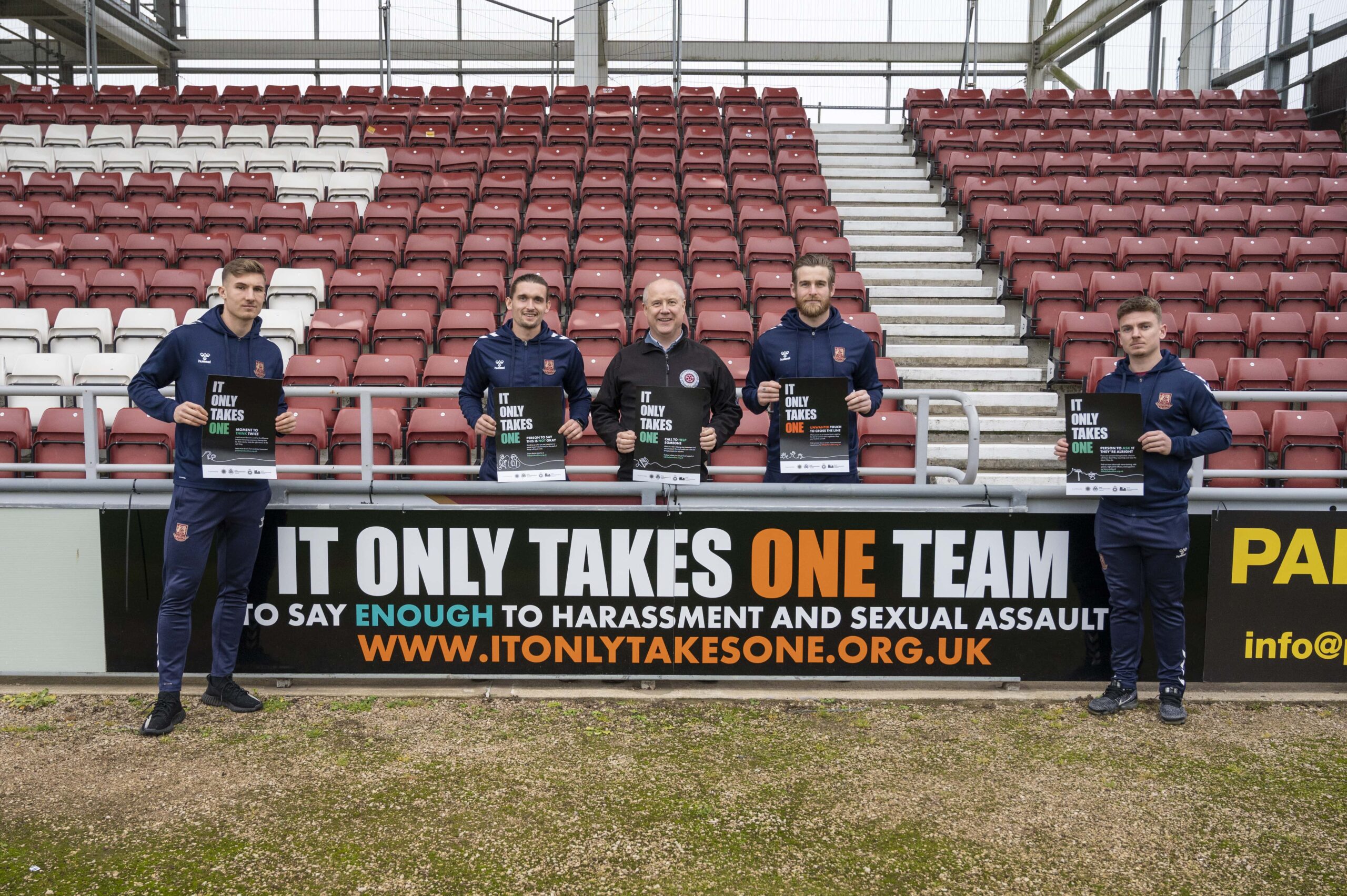 Harvey Lintott, Ben Fox, PFCC Stephen Mold,, Lee Burge and Sam Hoskins next to the It Only Takes One advertising board at Sixfields Stadium