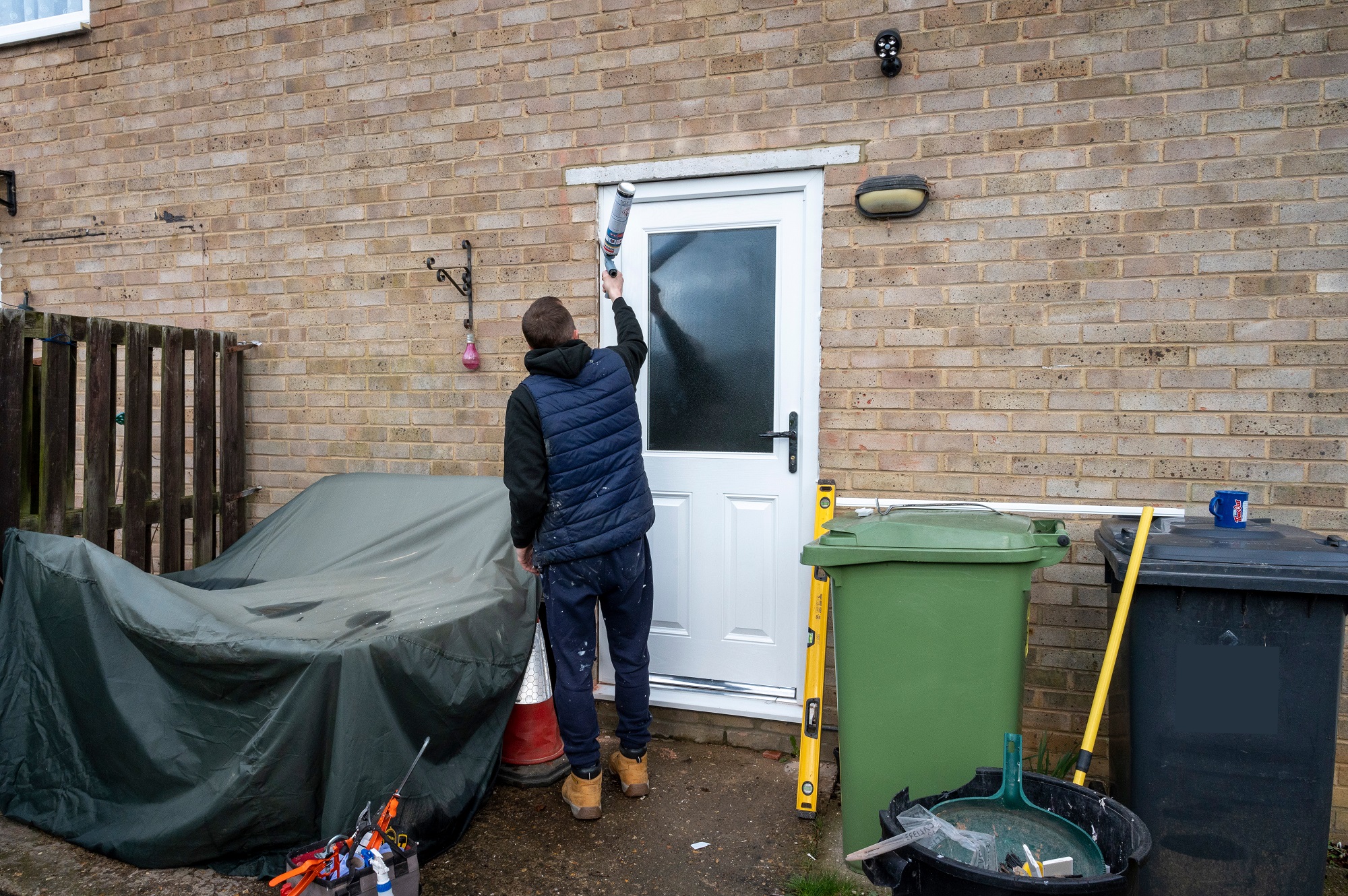 A worker fitting a new back door in the Queensway Estate