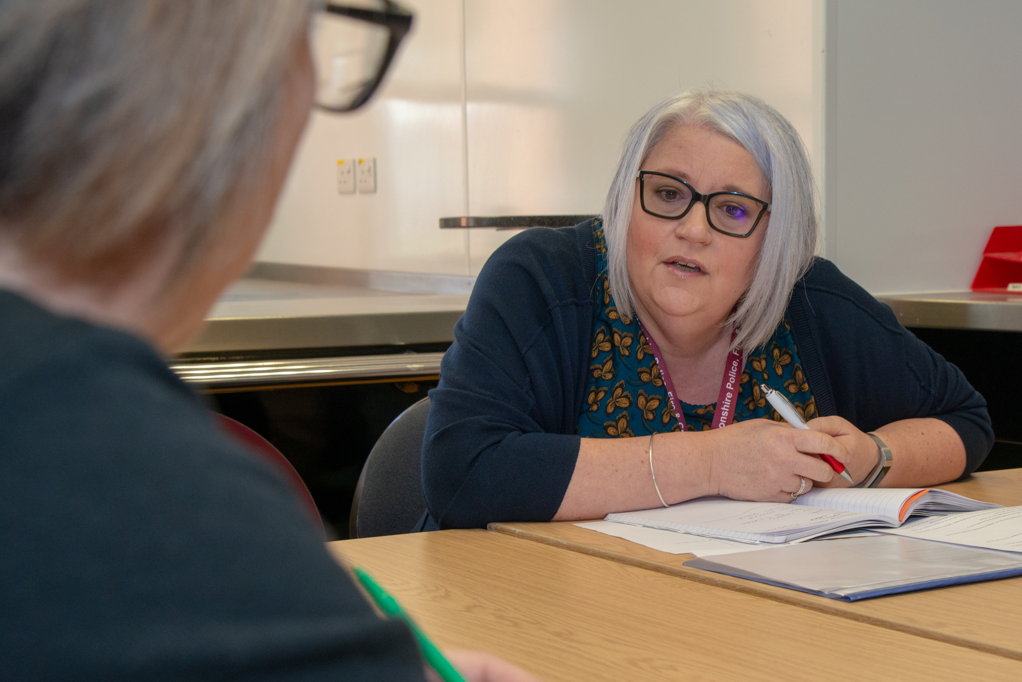 Two members of the Adverse Childhood Experiences Team a talking at a table