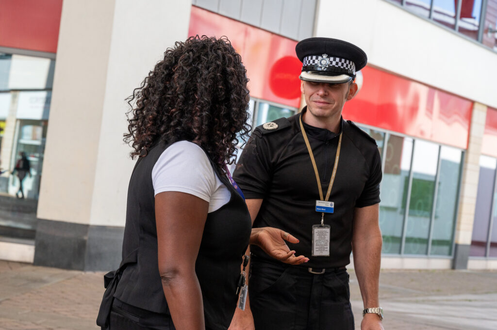 ACC Adam Ward in police uniform talking to DPFCC Marianne Kimani