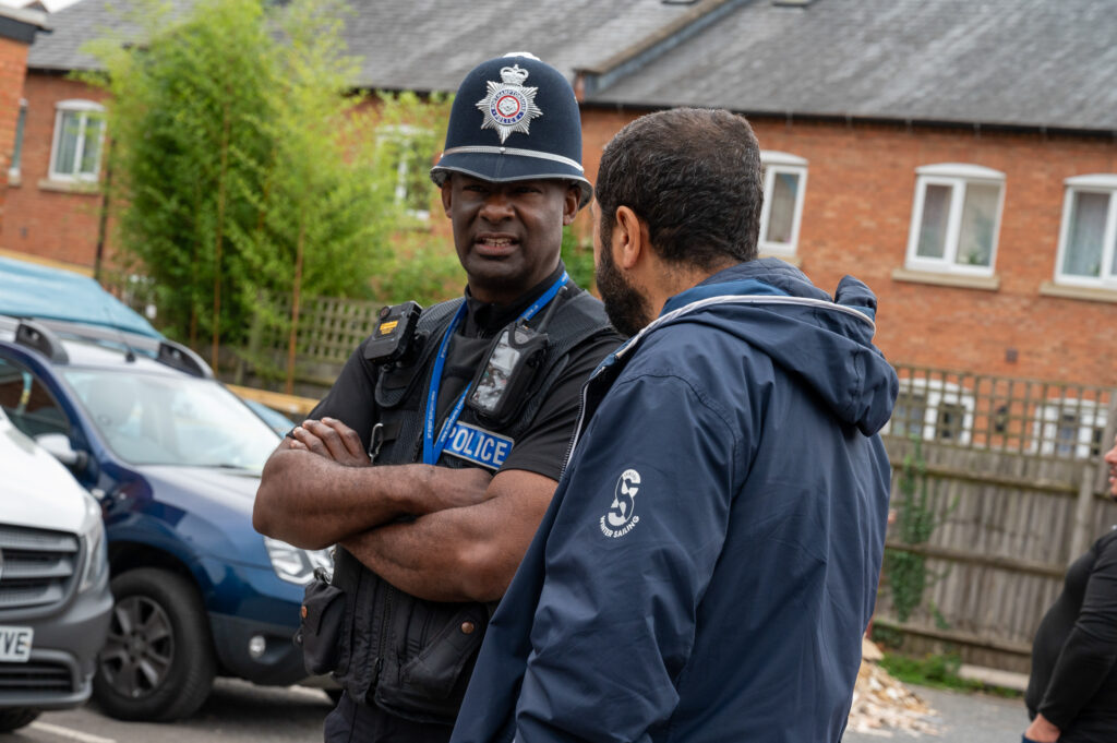 Sergeant Rodney Williams wearing black police uniform and hat speaking to member of Clare Street Mosque