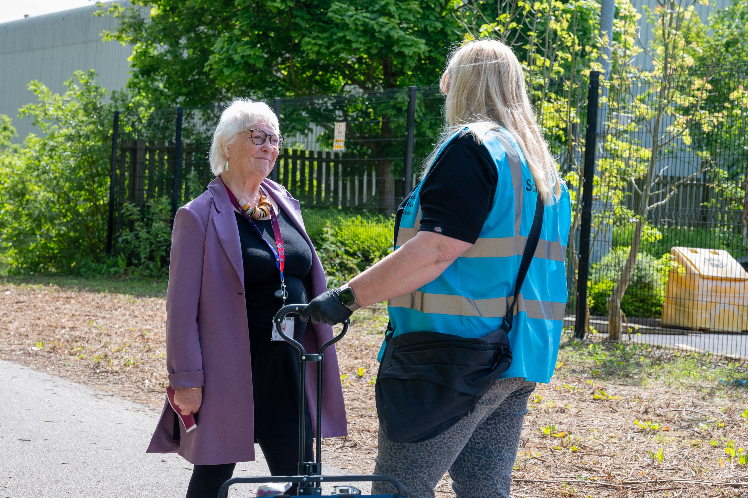 Police Fire and Crime Commissioner Danielle Stone wearing purple coat speaks to Immediate Justice Supervisor wearing a blue hi-visibility vest