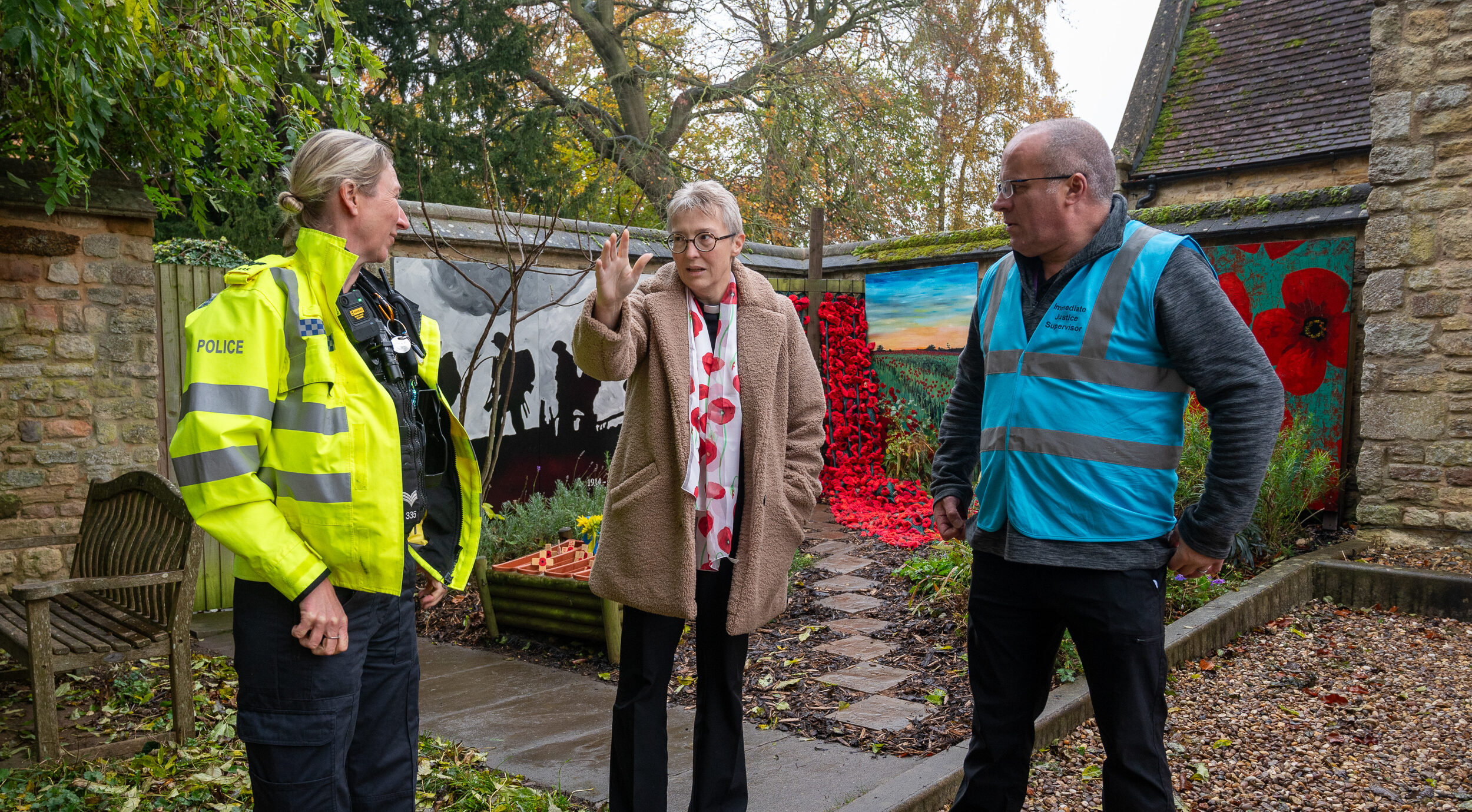 Police Sargent Lorna Clarke, Rev'd Paula Challen and Clive Sparley stood talking in a Remembrance Garden