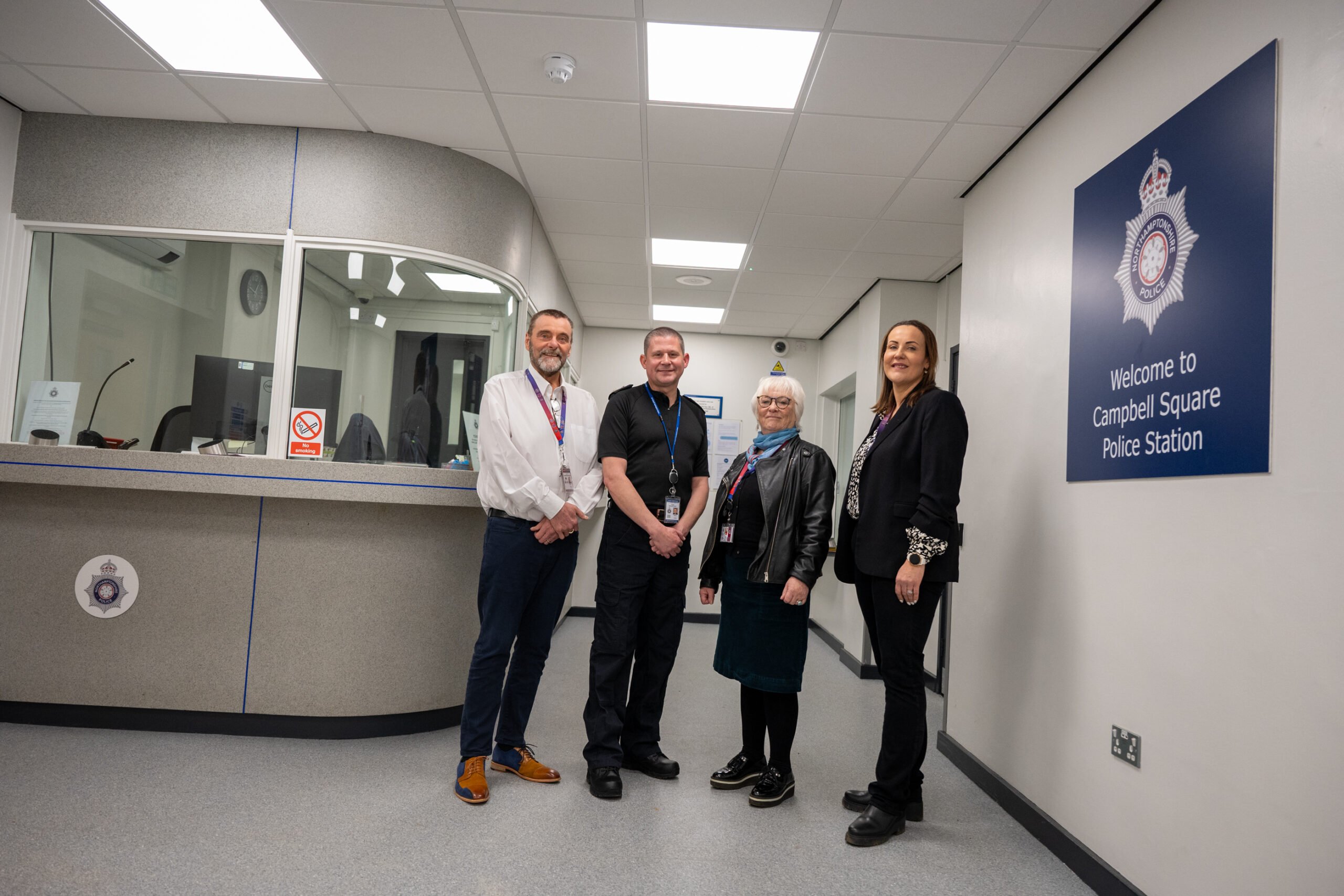 Deputy Property Operations Manager MJ De Bruyne Walker, Chief Constable Ivan Balhatchet, Police, Fire and Crime Commissioner Danielle Stone, and Head of Property Kate Perriss stand next to the new front desk at Campbell Square Police Station in Northampton