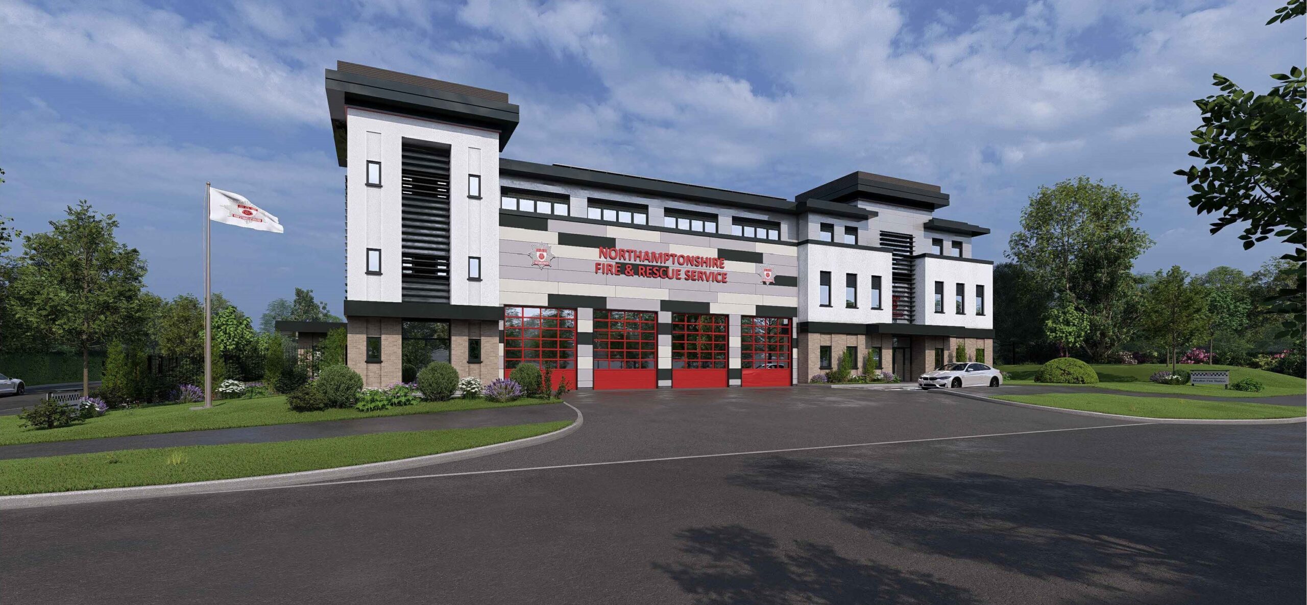 A computer generated image shows an artist's impression of how the new Moulton Fire Station will look. The exterior cladding is white and grey, and there are four red doors at the front for fire engines. The Northamptonshire Fire & Rescue Service logo is across the front of the building.