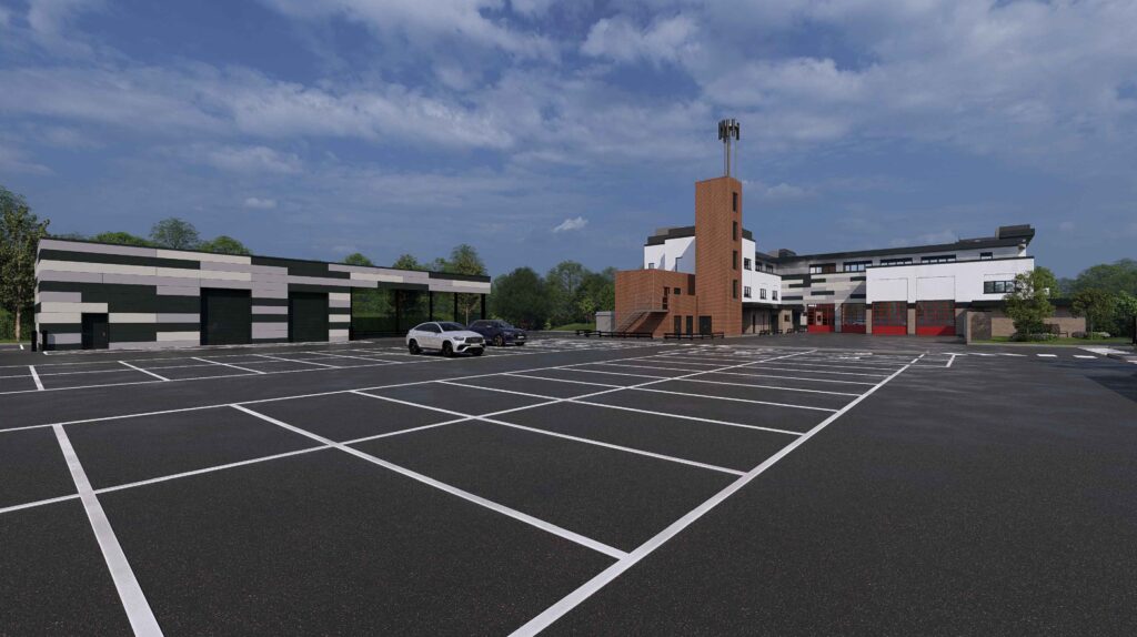 A CGI image shows an artist's impression of the proposed new Moulton Fire Station. In the foreground are a number of grey parking spaces. To the left is a cladded smokehouse, and at the back is the white exterior of the fire station and the red-bricked drill tower.