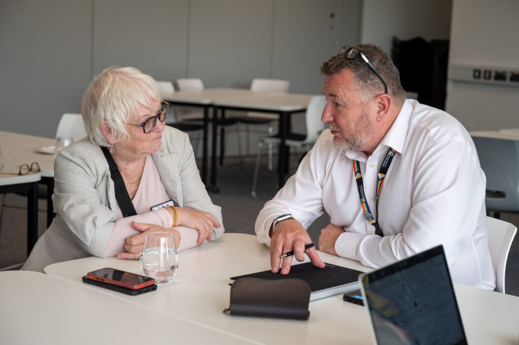 Danielle Stone talking to a member of university staff at a table