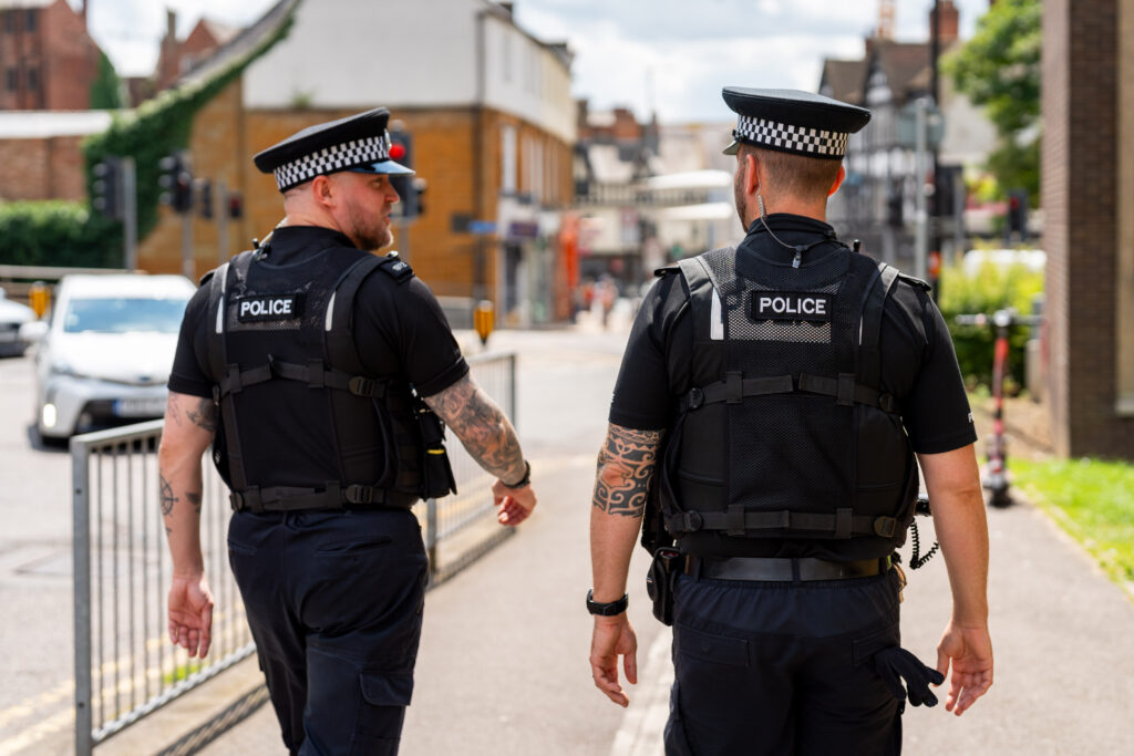 Two police officers walking through Northampton town centre