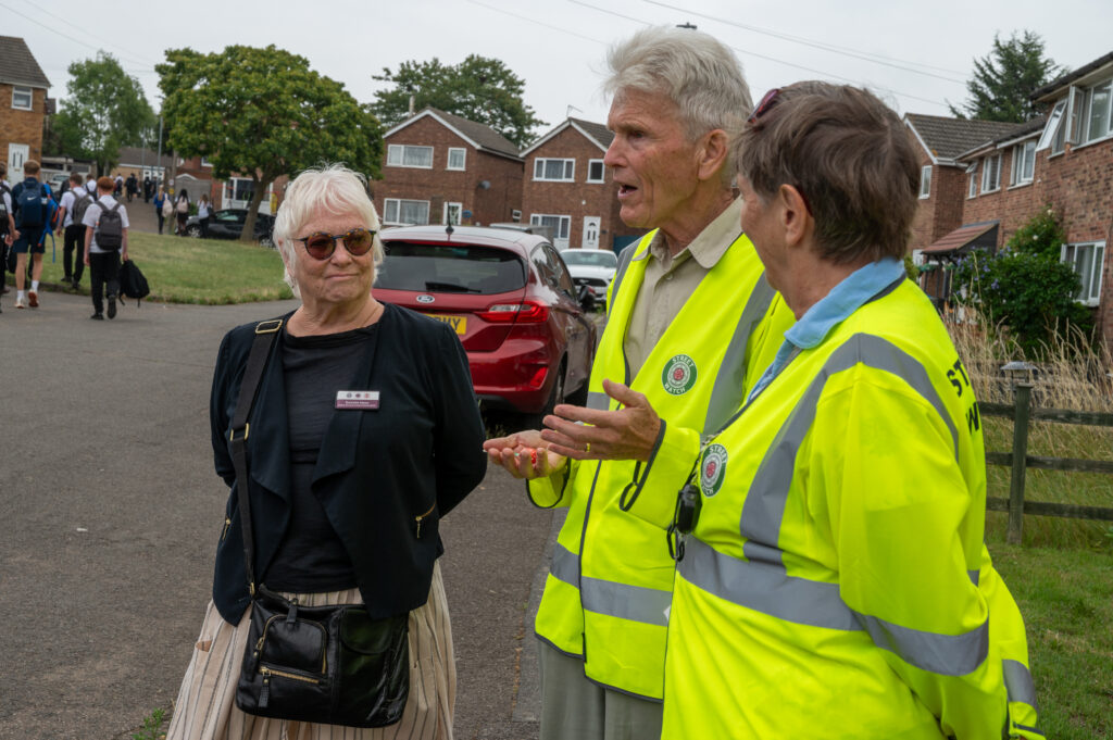 PFCC Danielle Stone talking to two people in high vis jackets from the street watch scheme