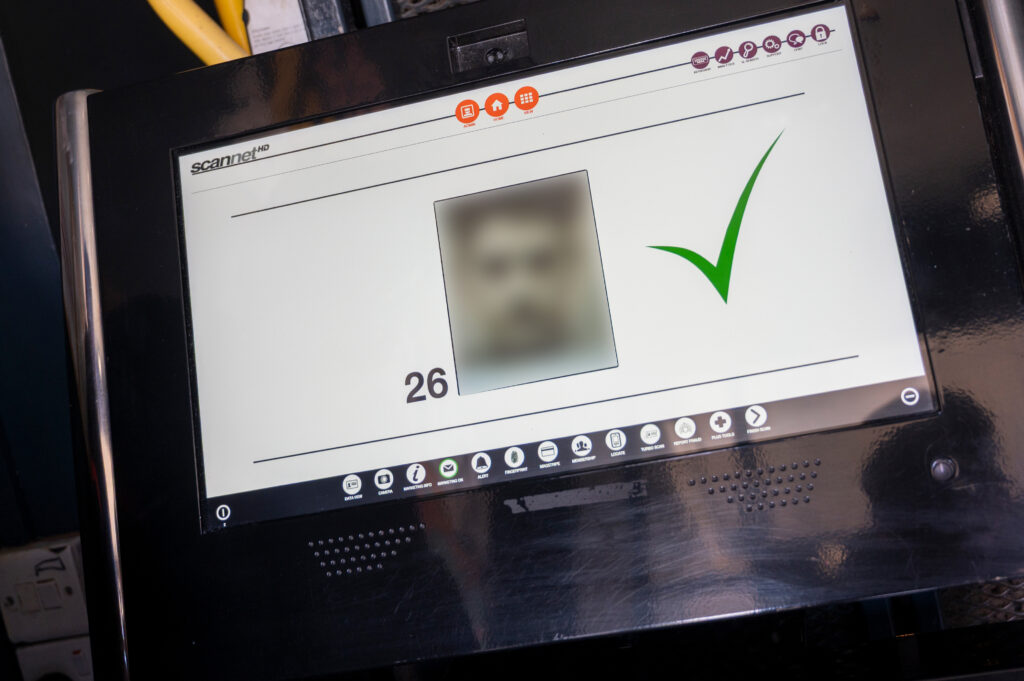 A close-up of a scanner screen showing a scanned document within the "scannet HD" interface. The screen features icons at the top and bottom, a blurred document image in the center, a large green checkmark on the right indicating successful scanning, and the number "26" below the document.
