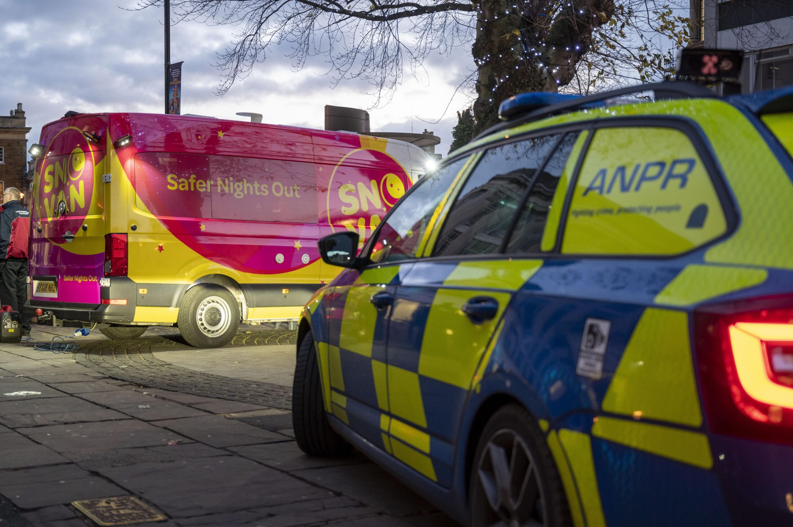 A Northamptonshire Police response vehicle is parked in front of the big pink and yellow Safer Nights Out van in Northampton